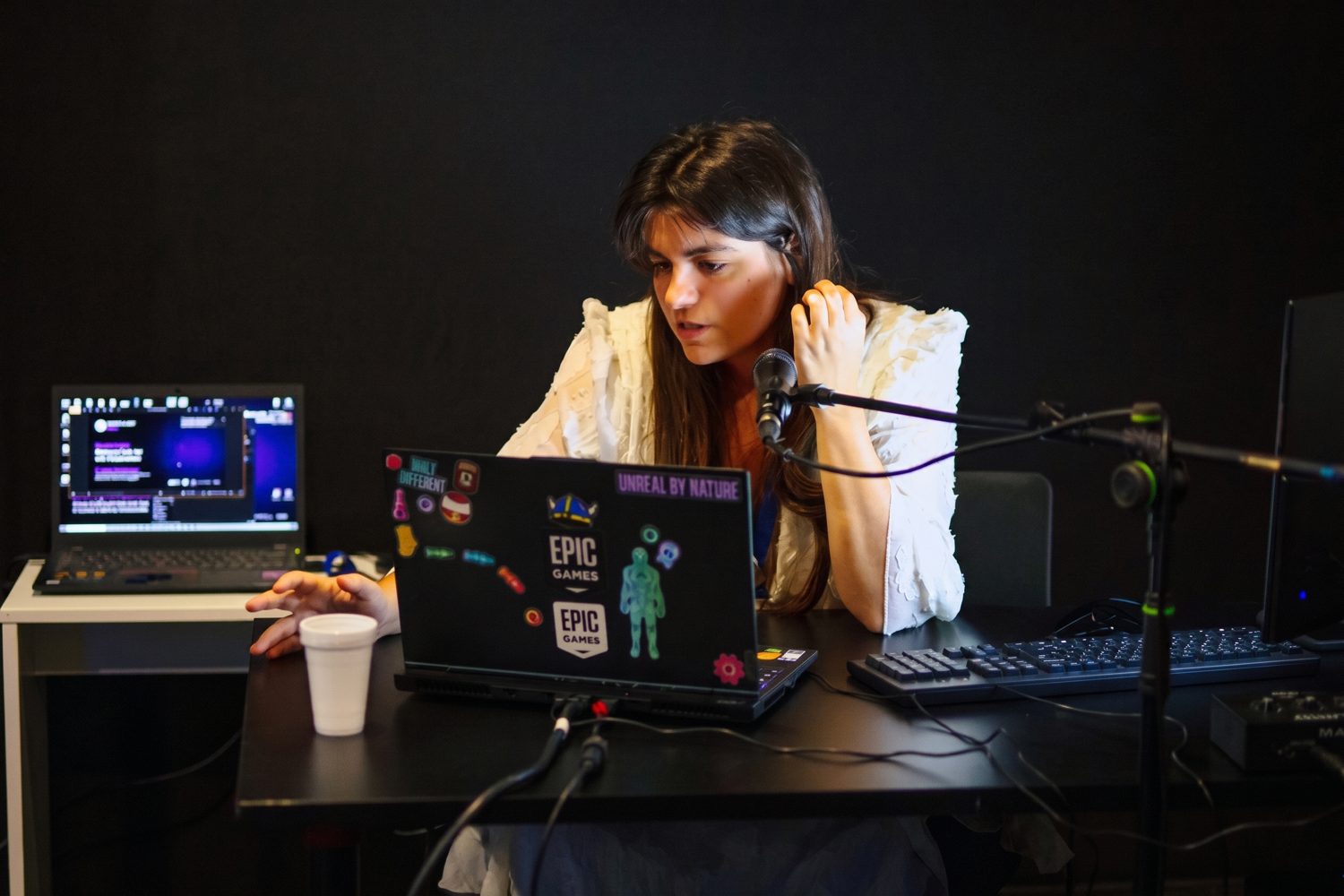 Elena Dimopoulou at a laptop and microphone during a live Unreal Engine session in the studio